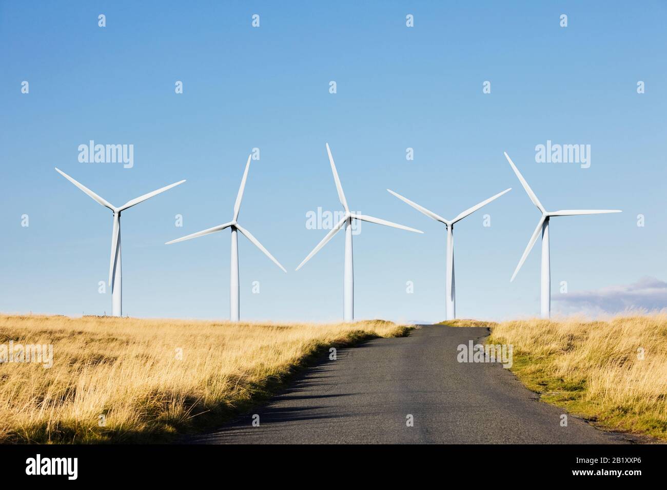 Wind farm at the end of a rural countryside road Stock Photo