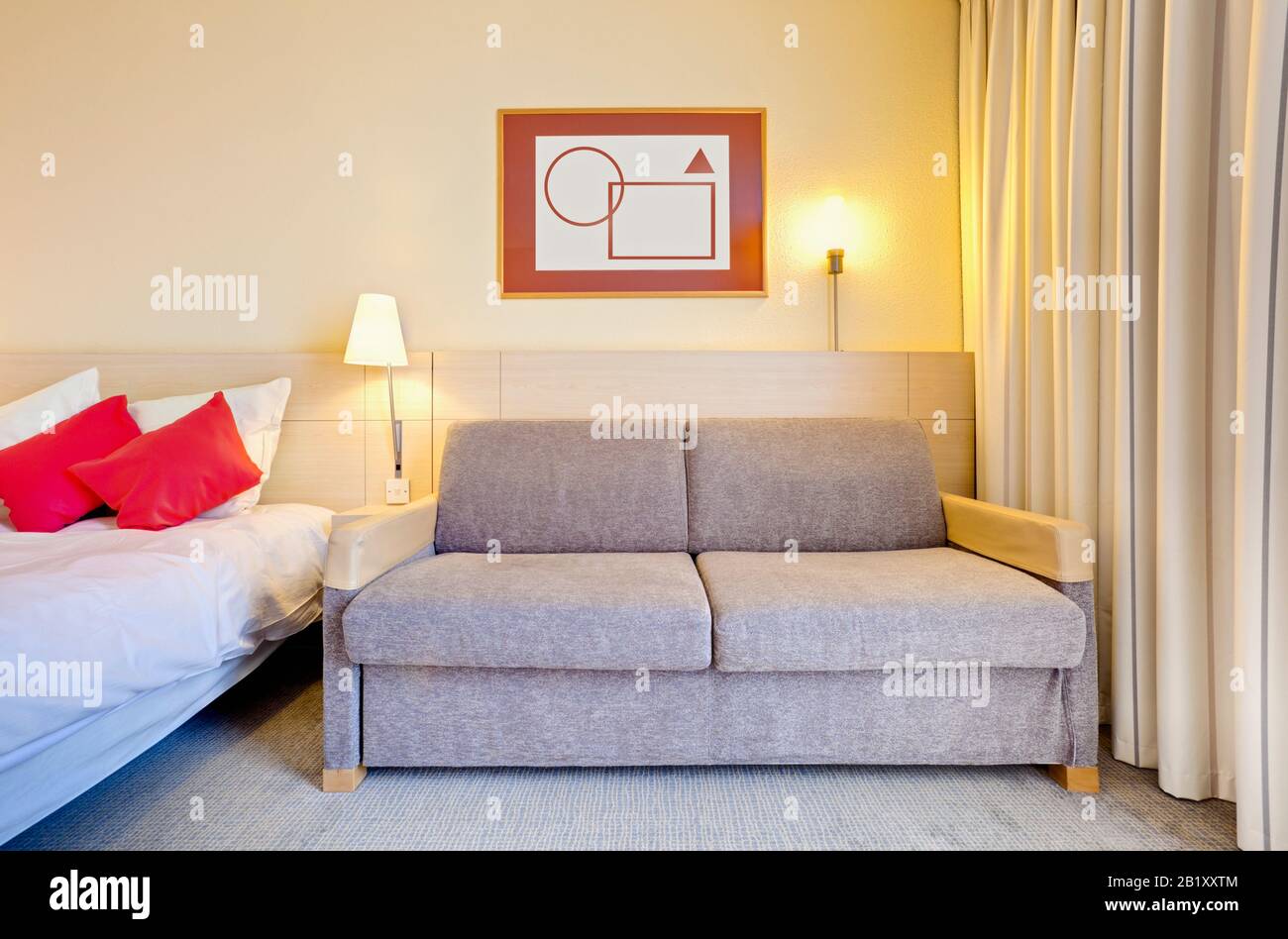 Basic hotel room with bed and sofa, England UK Stock Photo