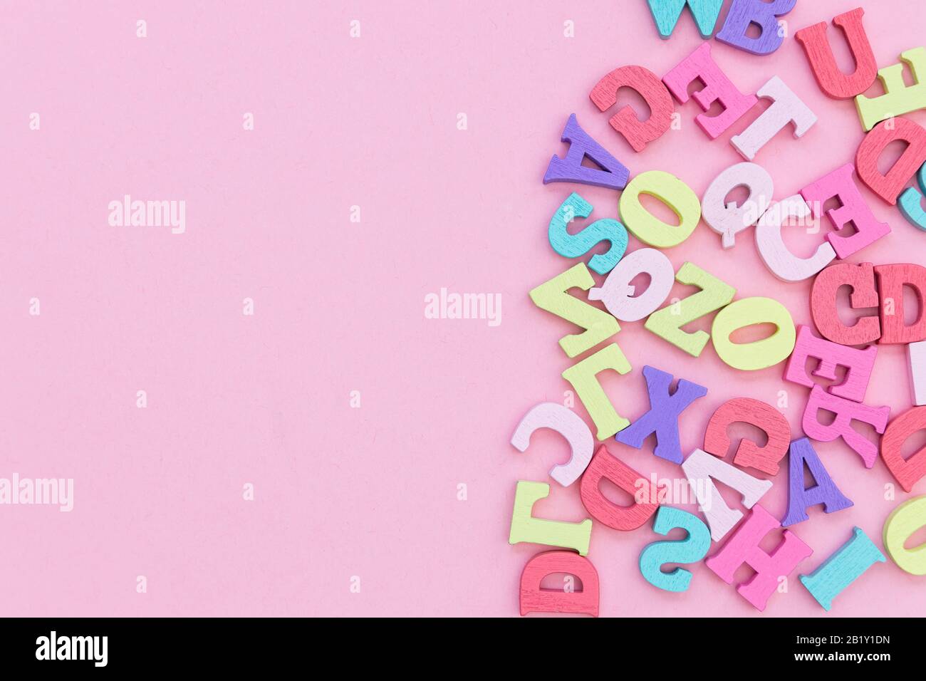 Alphabet wooden letters abstract on pink color background Stock Photo