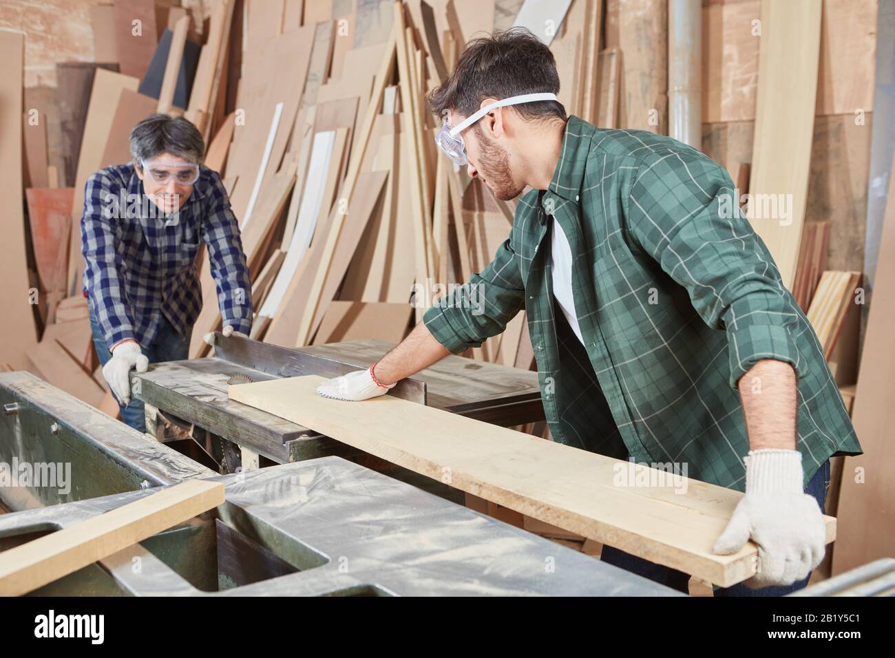 Two Carpenters Work With Wood And A Circular Saw In The Workshop Stock 