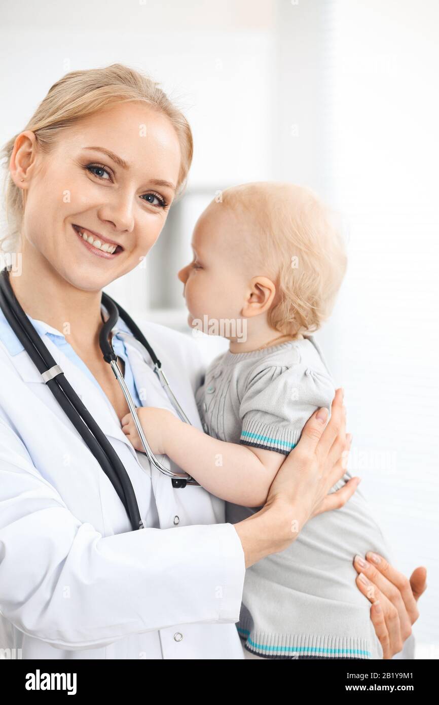 Doctor and patient in hospital. Little girl dressed in grey dress is ...