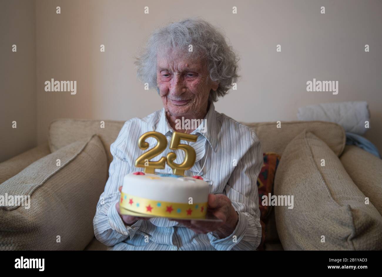 Great-great grandmother Doris Cleife holds a birthday cake with candles showing the number 25, in her flat at Housing 21's Brunel Court in Portsmouth, as she prepares to turn 100 years old on 29th February, though it is only the 25th time Doris has been able to celebrate her birthday due to being born during a leap year. Stock Photo