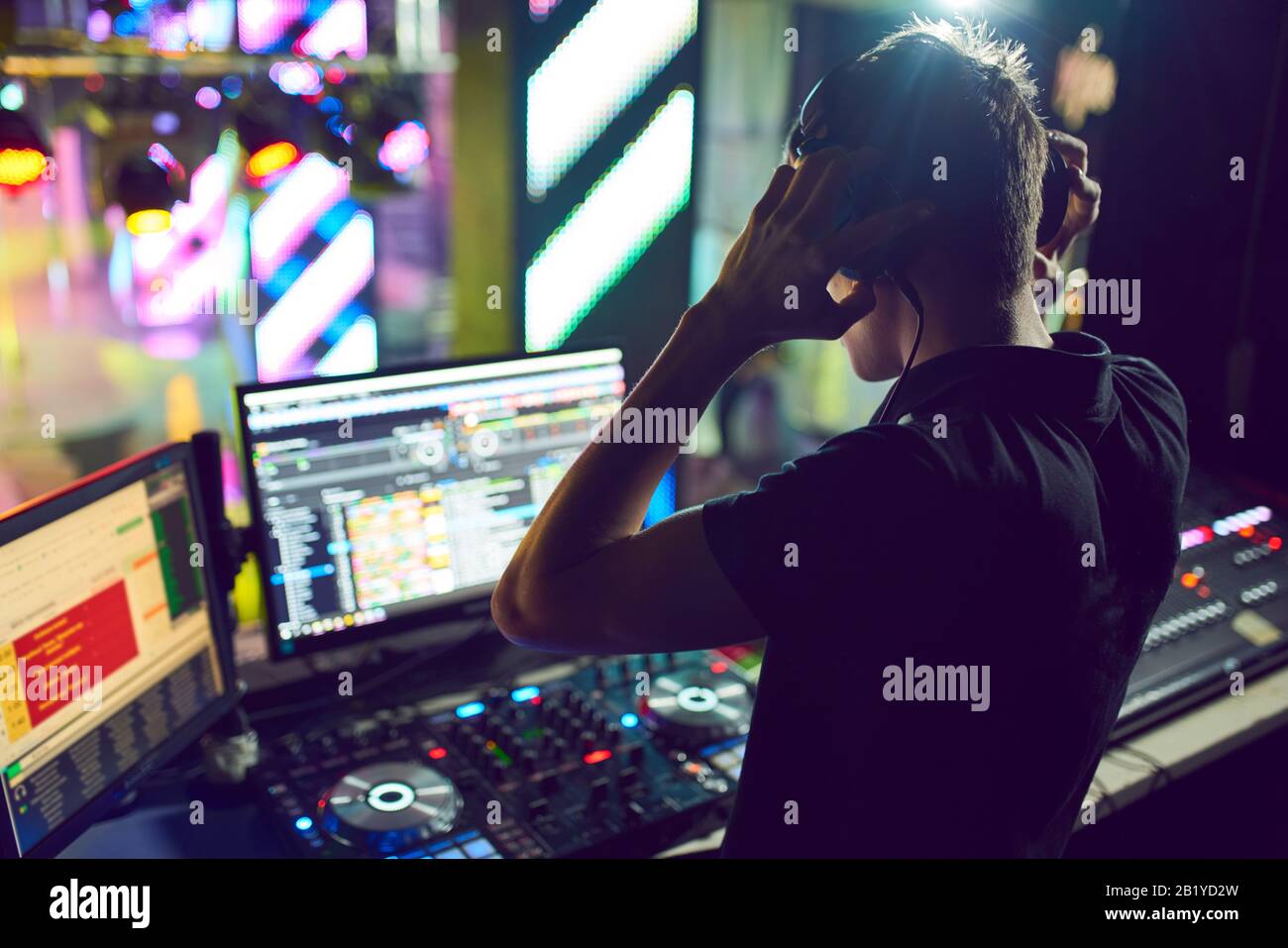 Dj mixes the track in the at party. In the background laser