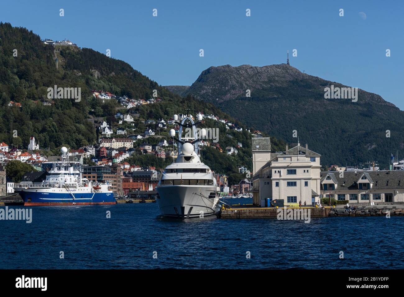 Superyacht Anna moored at Tollbodkaien in Bergen, Norway. Vaagen and Mount Ulriken, Mount Floeyen (Fløyen) and Bryggen in background. Stock Photo