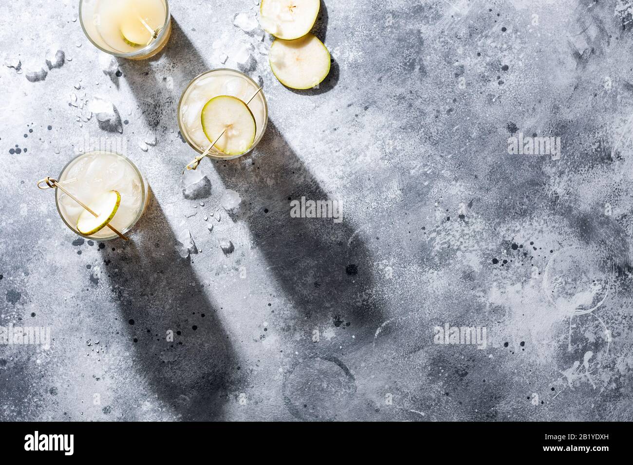 A short glass of refreshing pear soda water mocktail or cocktail on gray concrete background. Non alcoholic summer drink. Horizontal orientation Stock Photo