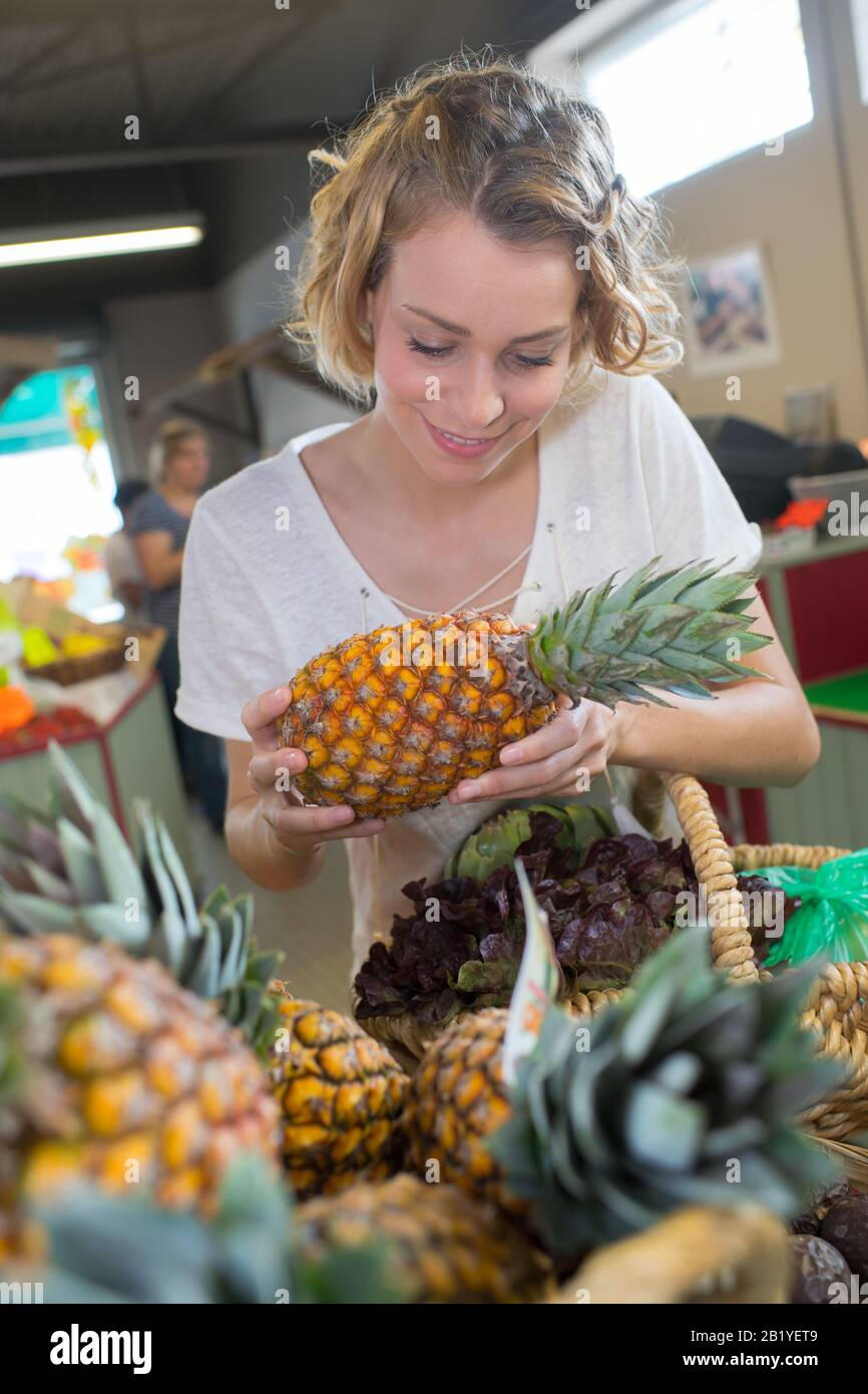 woman choosing fruits at supermarket and holding pineapple Stock Photo ...