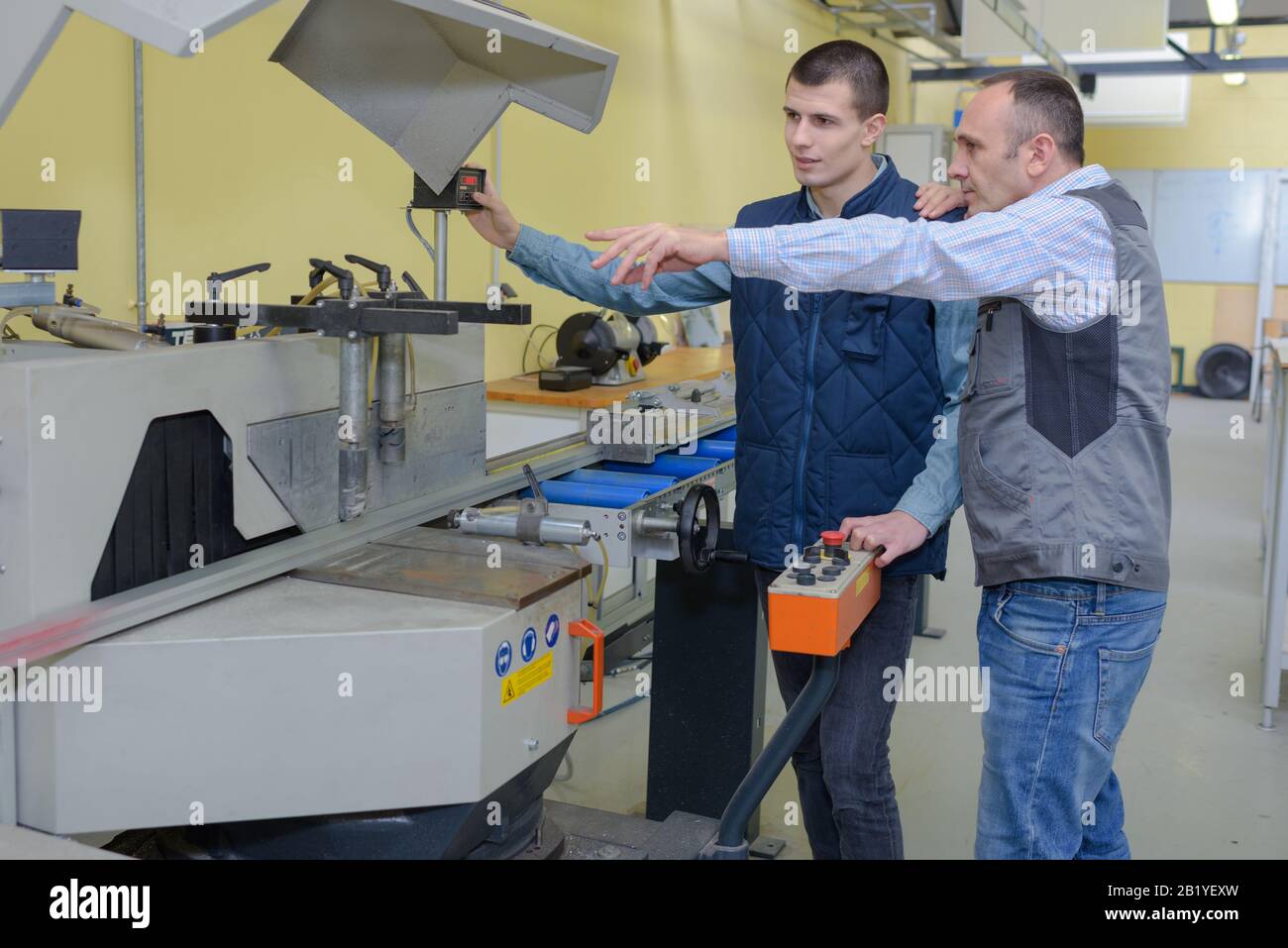 engineer training apprentices on cnc machine Stock Photo
