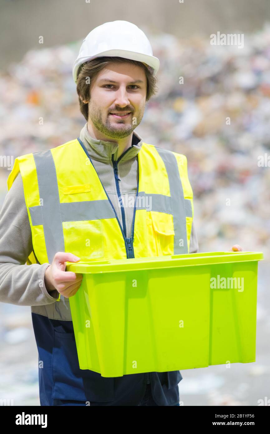 dumping site worker holding plastic container Stock Photo