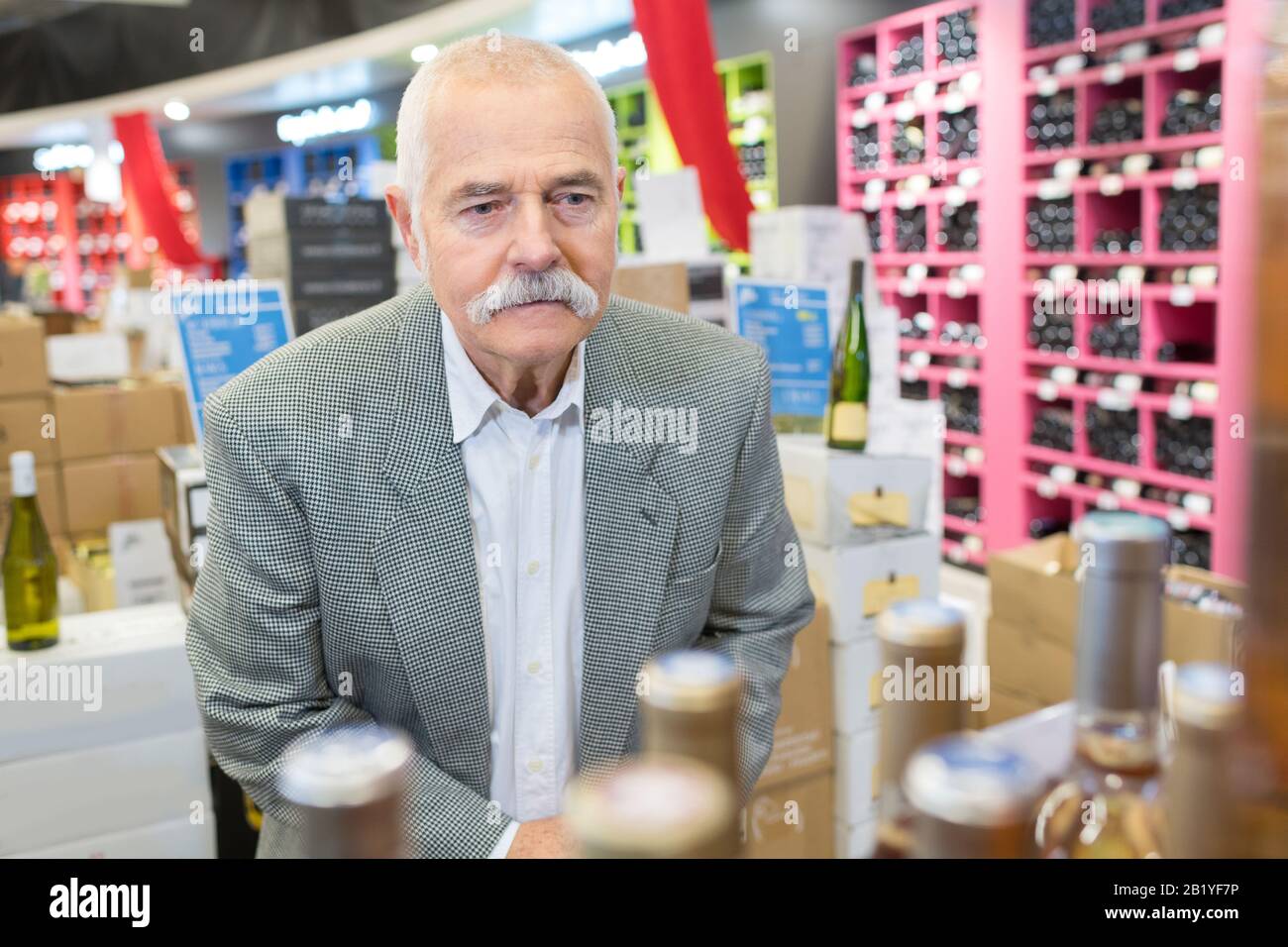 older man choosing wine at the supermarket Stock Photo