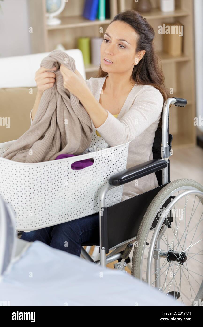 woman in wheelchair with a laundry basket Stock Photo Alamy