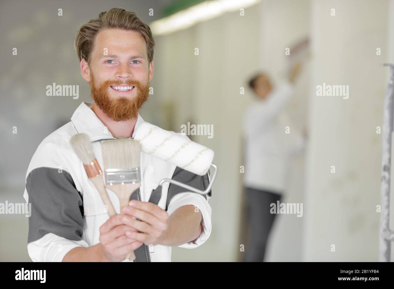 men with brush and roller smiling at camera Stock Photo