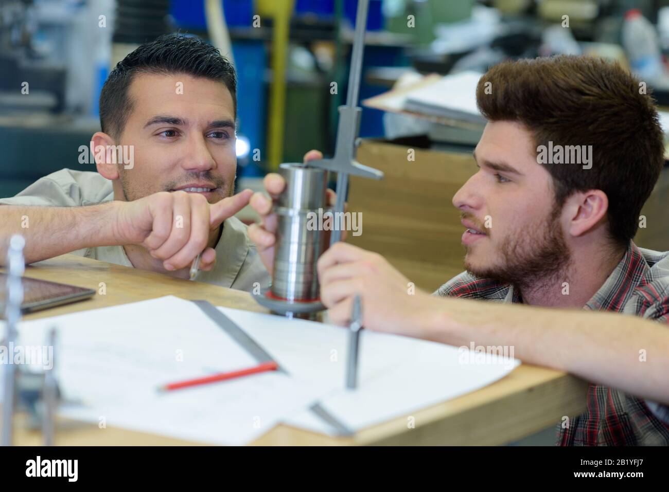 two worker shaping metal in workshop Stock Photo