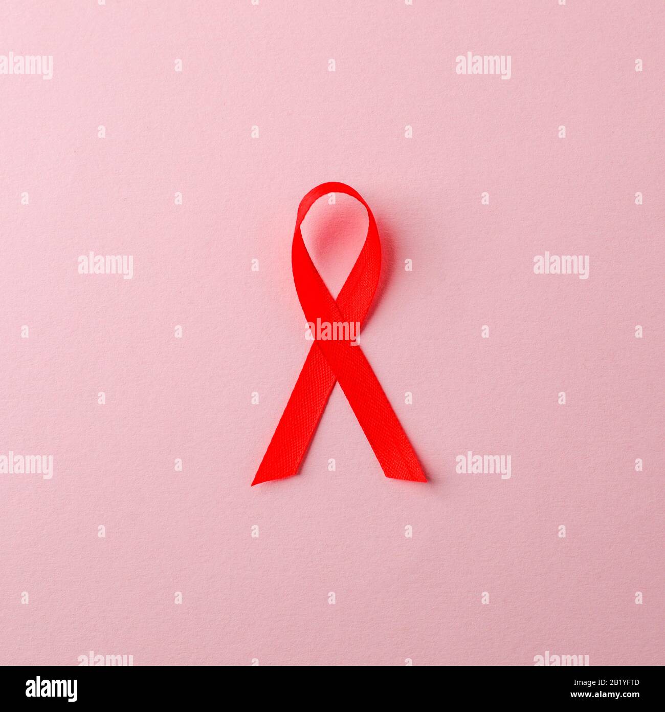 AIDS awareness red ribbon on pink background. world aids day concept ...