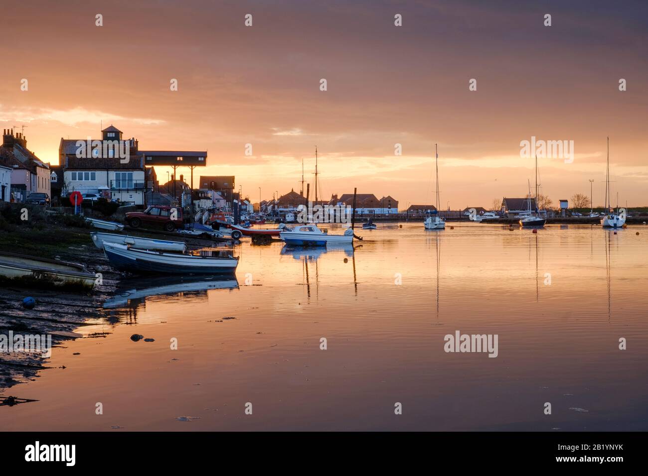 Tranquil scene of boats at anchor in the Port of Wells at sunset. Stock Photo