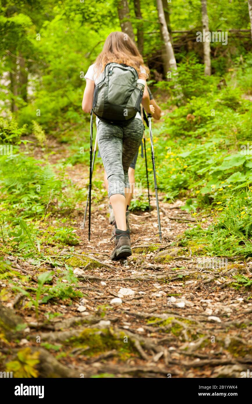 Active hiker hking on a narrow path in forest on a early spring afternoon Stock Photo