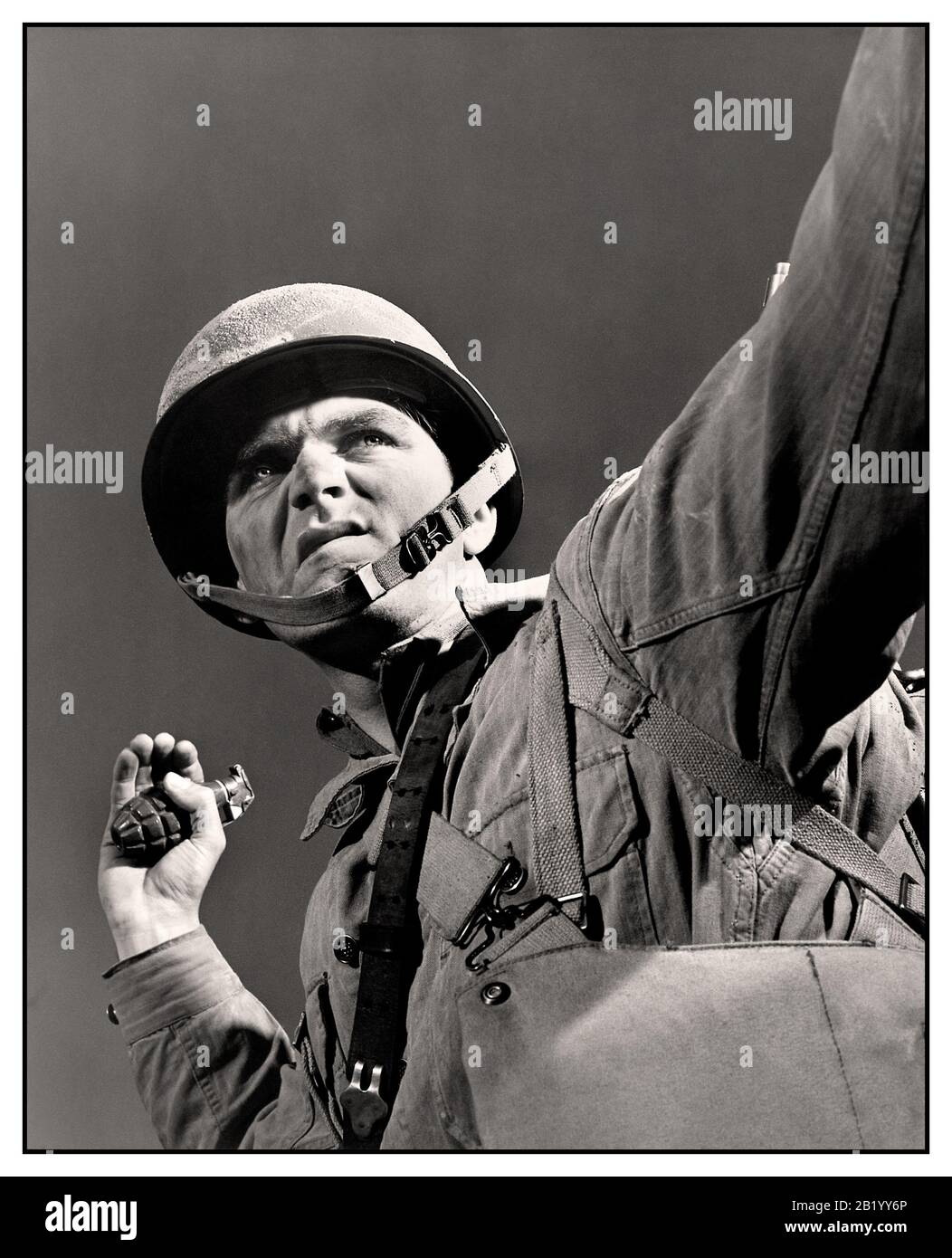 WW2 American Propaganda photo of an American GI infantryman army soldier about to throw a grenade, image titled 'A package for Hitler' Fort Belvoir, Virginia. Grenade thrower infantryman with look of determination on his face during training at Fort Belvoir, Virginia USA  preparing to throw his grenade. November 1942 Stock Photo