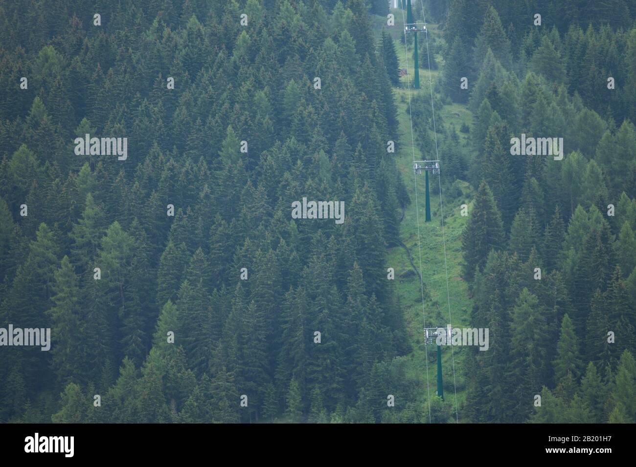 chair lift over a green forest hill in Val Gardena, Dolomites Stock