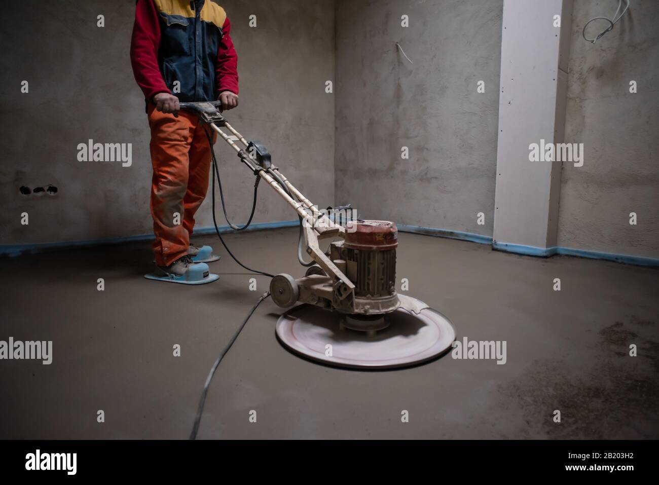 Laborer Performing And Polishing Sand And Cement Screed Floor On