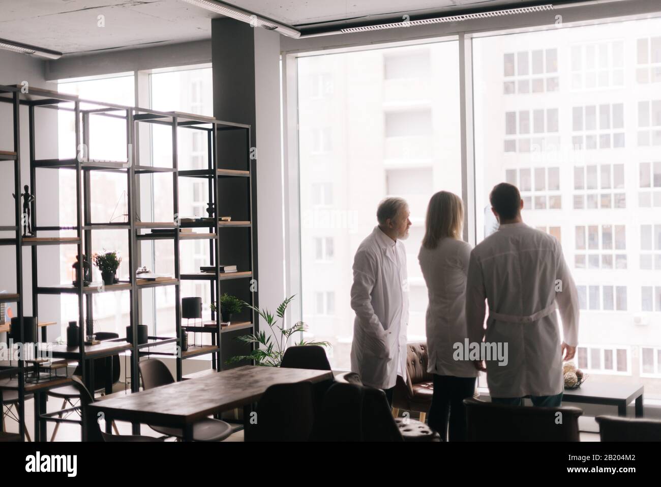 Three adult and young doctors examining X-ray scan together Stock Photo ...