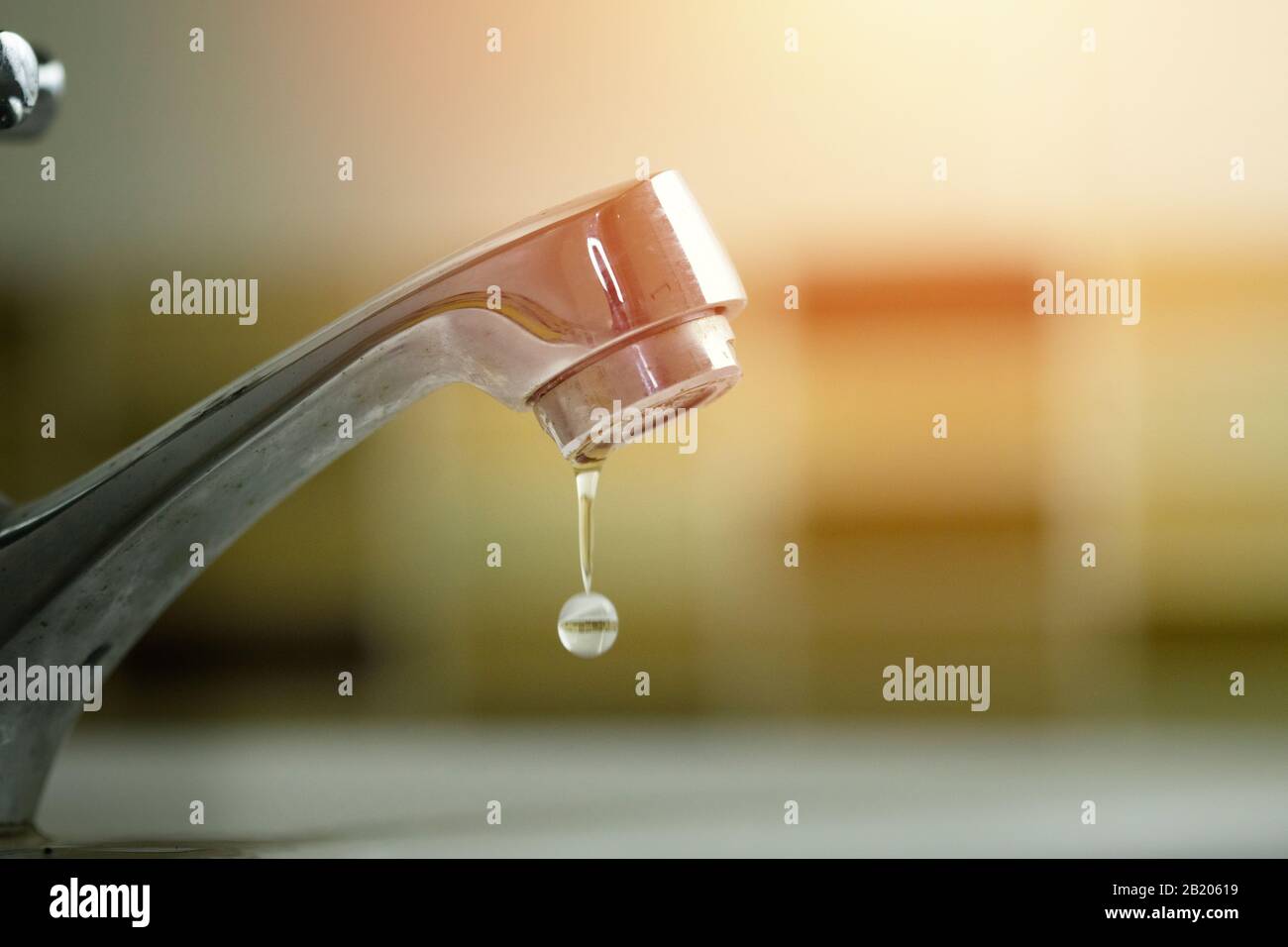 water tap with dripping waterdrop. Water leaking, saving concept Stock Photo