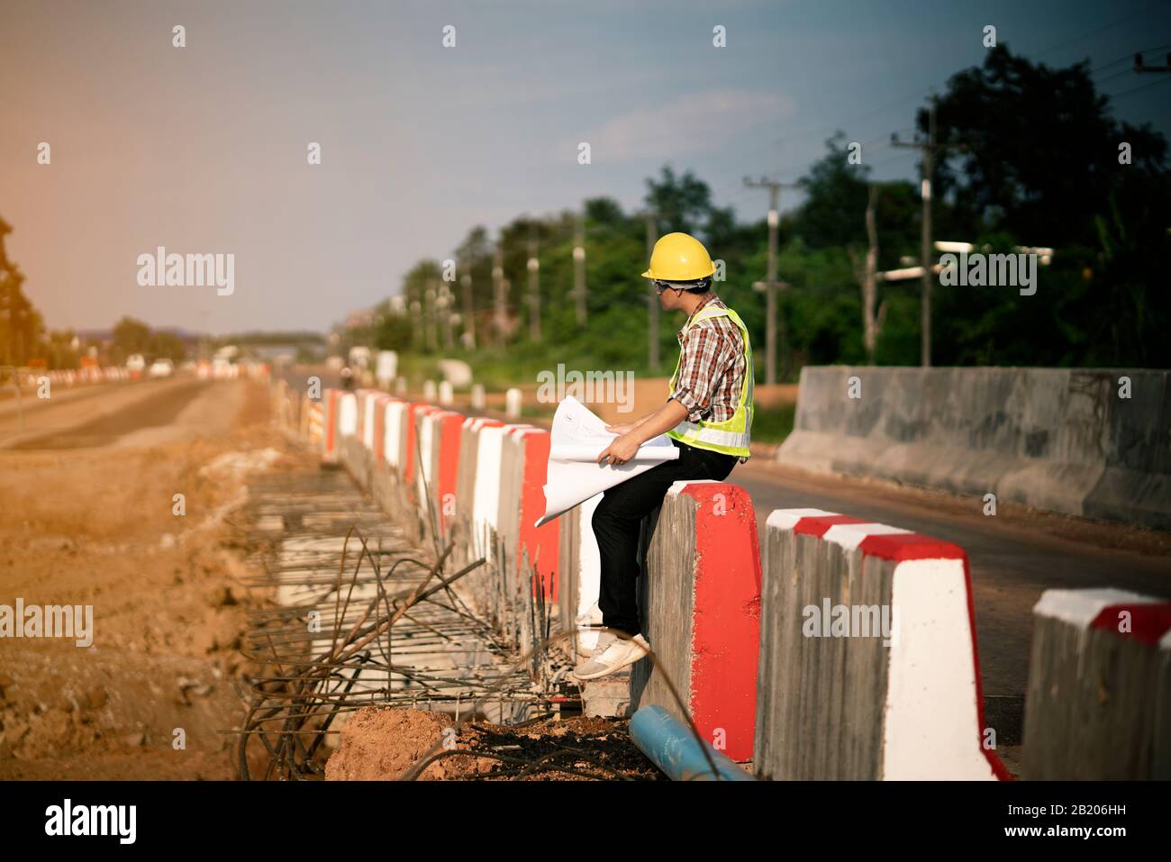 Engineer holding blueprint at construction site Stock Photo - Alamy
