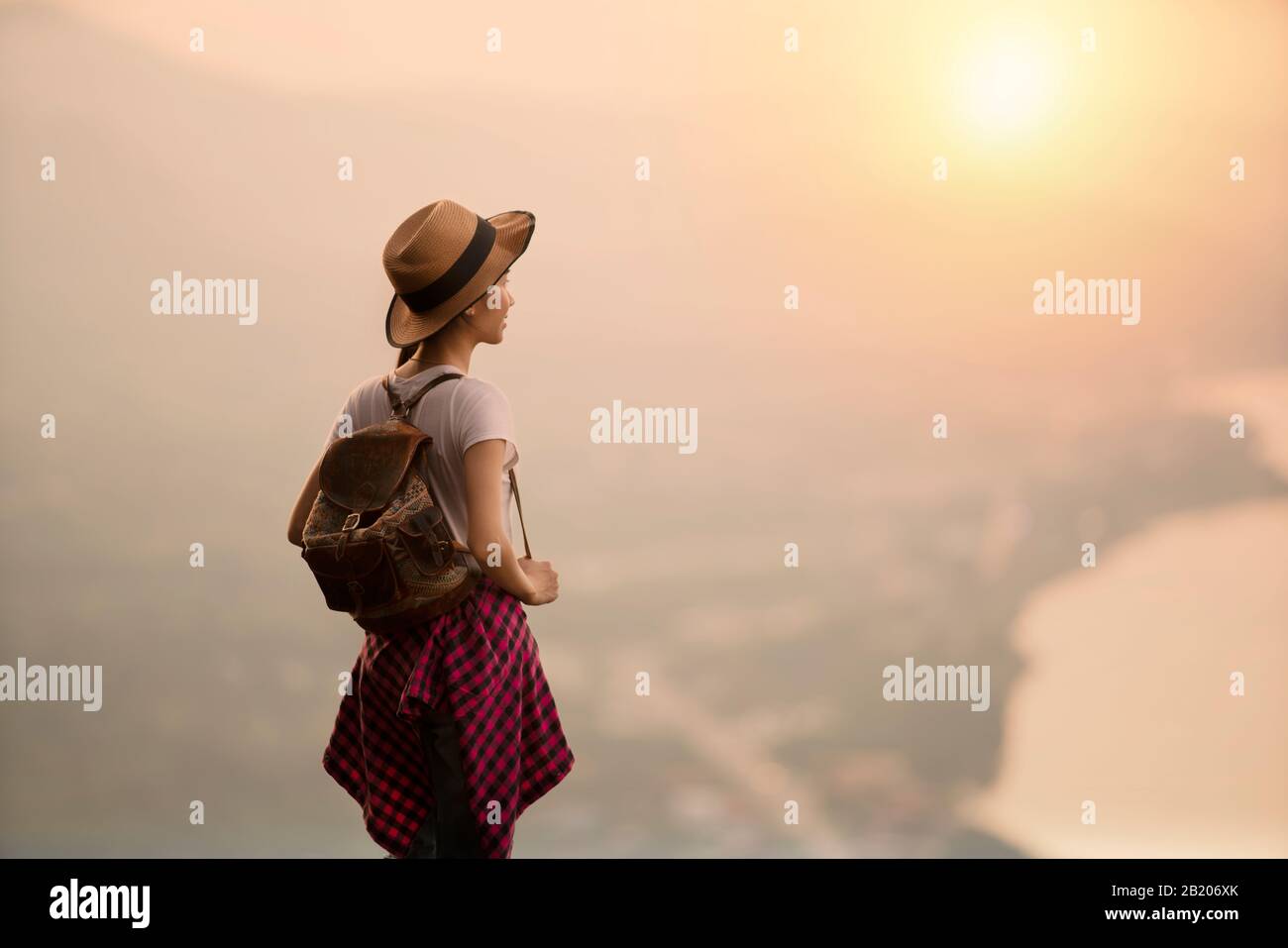 Beautiful woman standing on the edge of cliff with sunset or sunrise ...