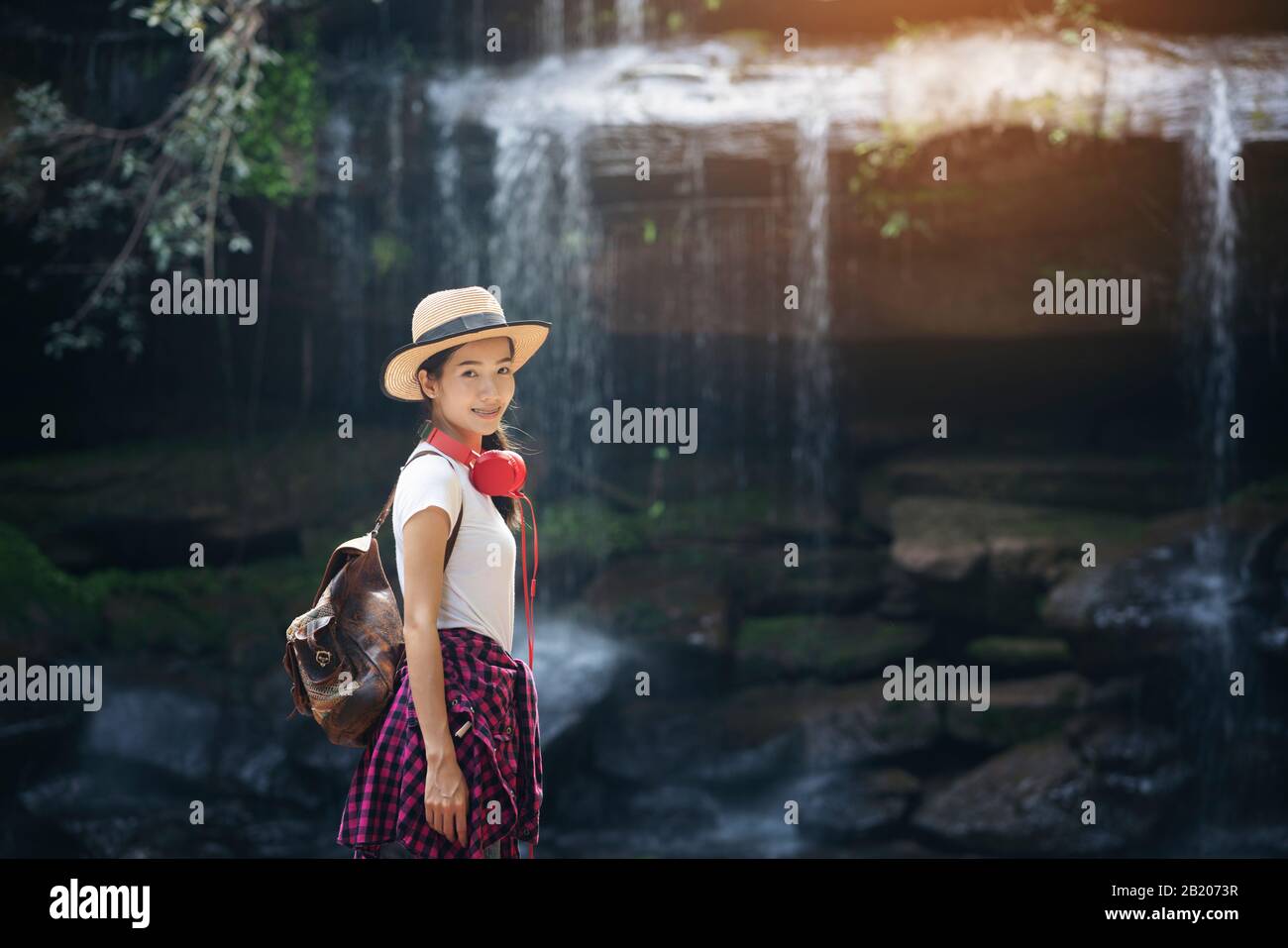beautiful woman standing in front of waterfall in rainforest Stock ...