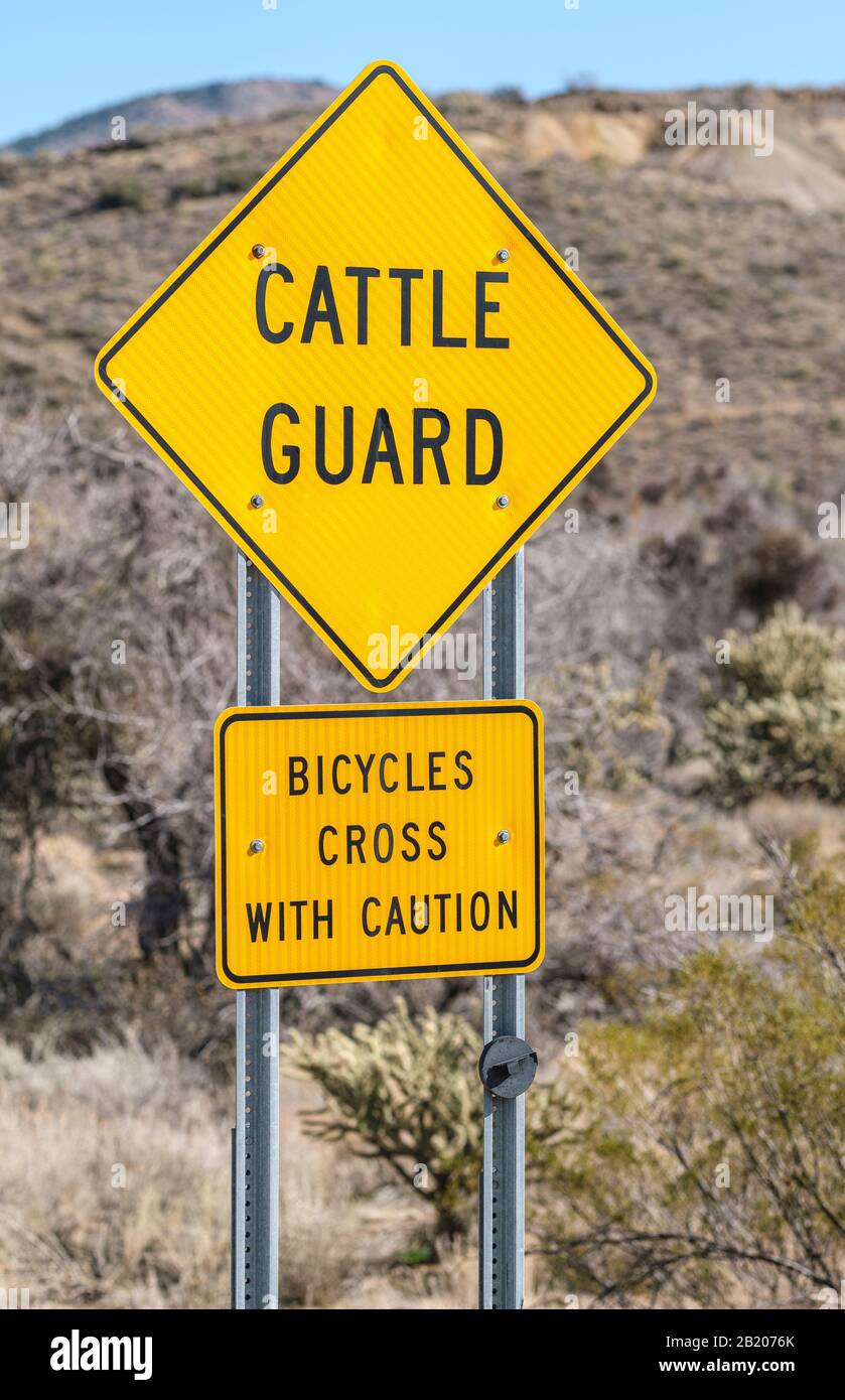 Cattle Guard & Bicycles crass with caution signs on approach to Chloride, Arizona, 86431, USA. Stock Photo