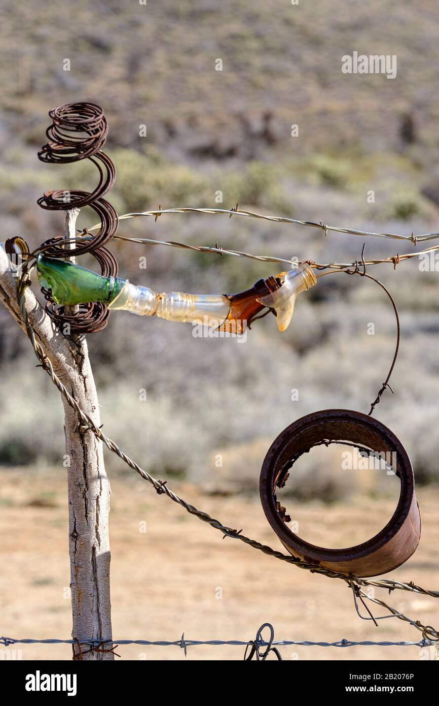 Fence made out of wire cans, bottles and random scrap on the bounday of the town of Chloride, Arizona, 86431, USA. T Stock Photo
