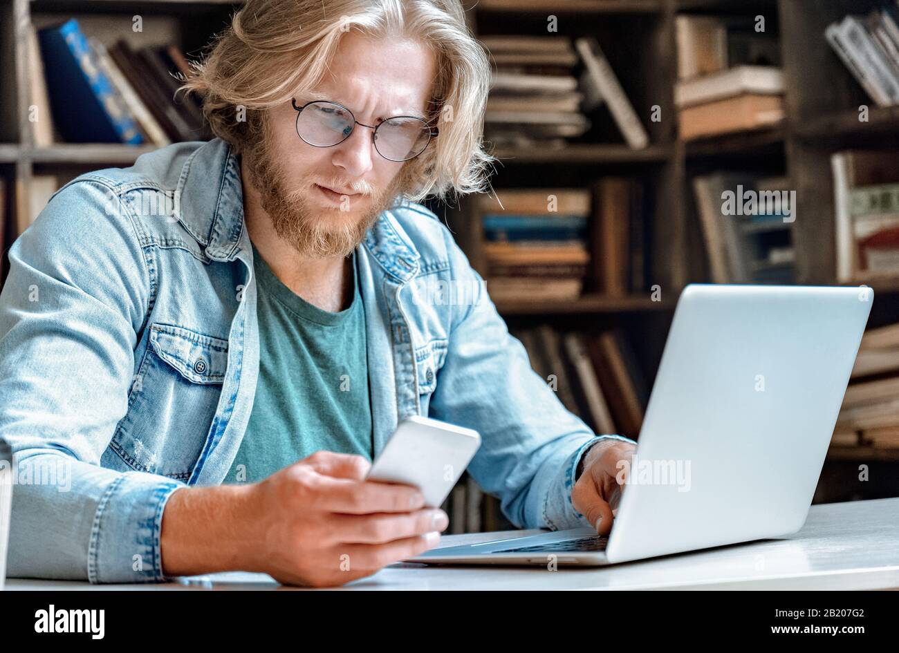 Confused concentrated man worried look at modern smartphone screen copy space. Stock Photo