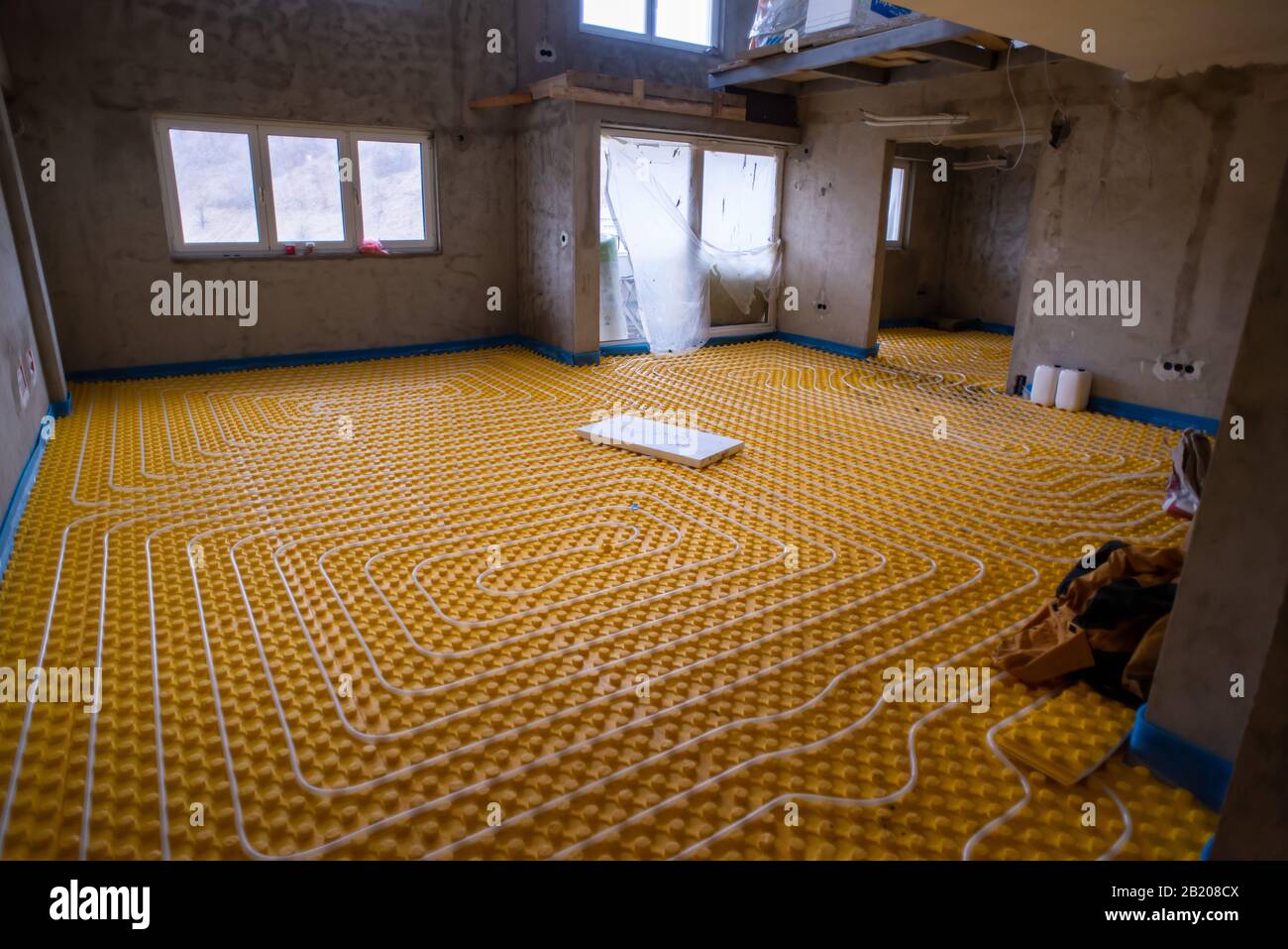 Picture of yellow underfloor heating installation with white polyethylene pipes on ...