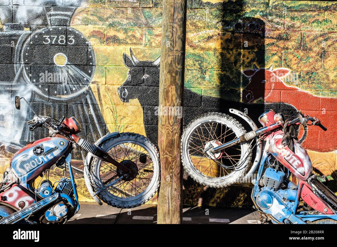 Exterior of Copper Cart, Seligman, Arizona, USA. Historic Route 66 sign and scenic mural on wall with motorbikes set in concrete Stock Photo