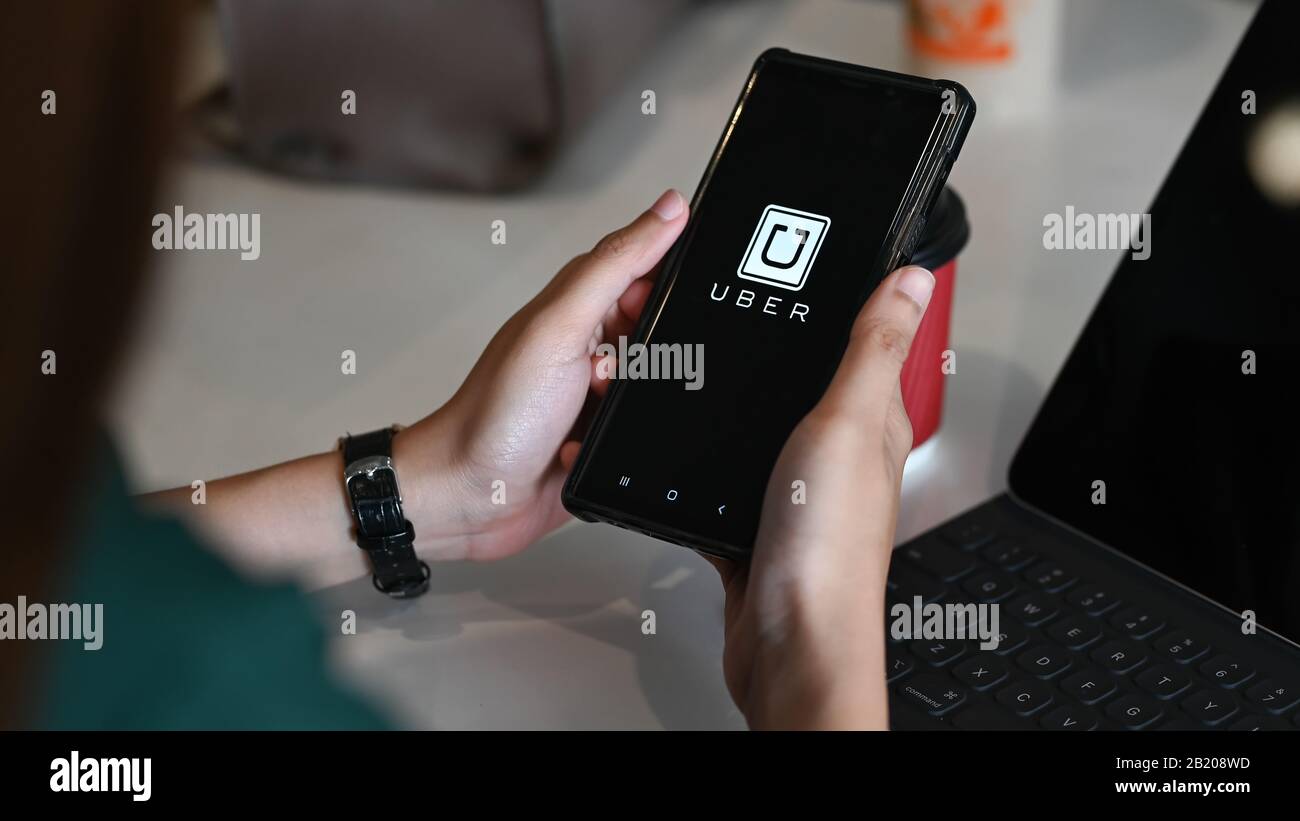 CHIANG MAI,THAILAND - FEB 02, 2020 : A woman hand holding Uber app 