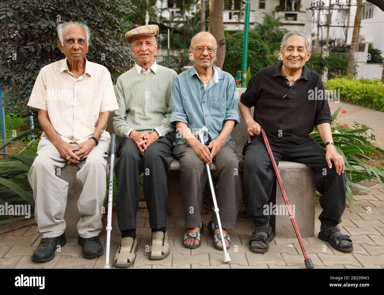 BENGALURU, INDIA - June 25, 2010. Group of old Indian senior men relax on a park bench in Bangalore, India Stock Photo