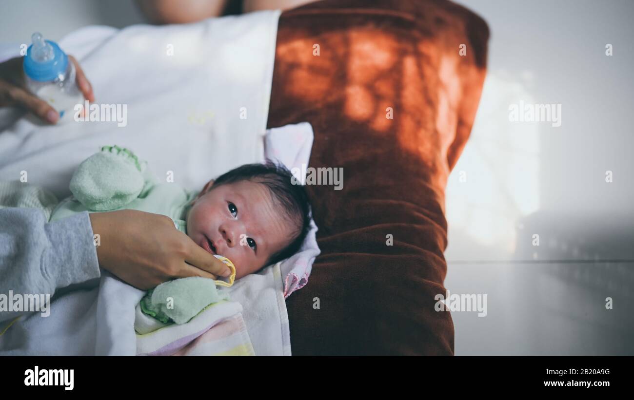 Photo of young mother wiping her little infant mouth after finished