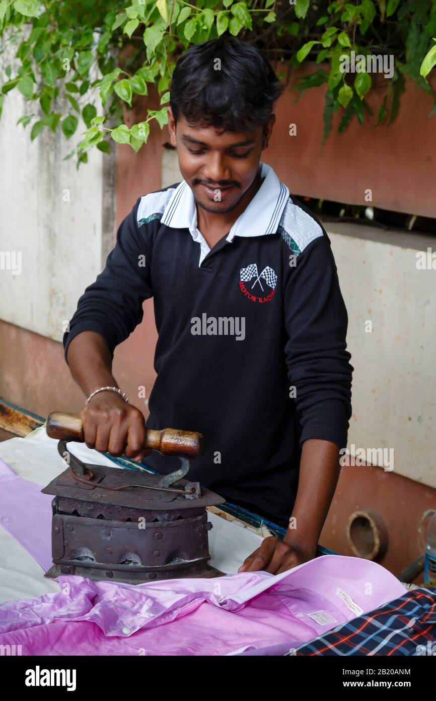 BENGALURU, INDIA October 24, 2012. Indian man ironing clothes
