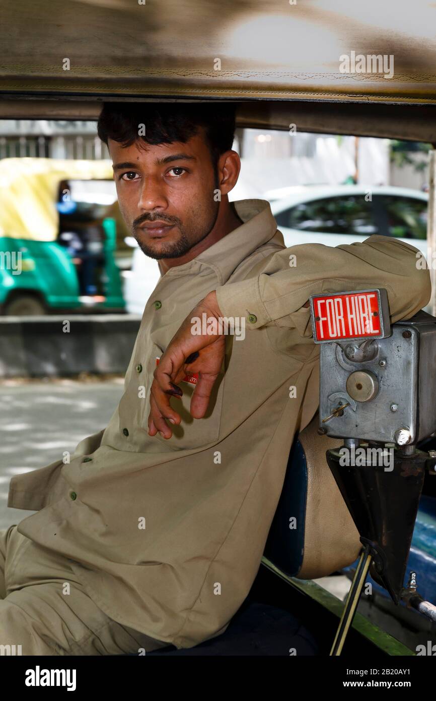 BENGALURU, INDIA - October 24, 2012. An Indian tuk tuk driver waits for a fare in his rickshaw, Bengaluru (Bangalore), India Stock Photo