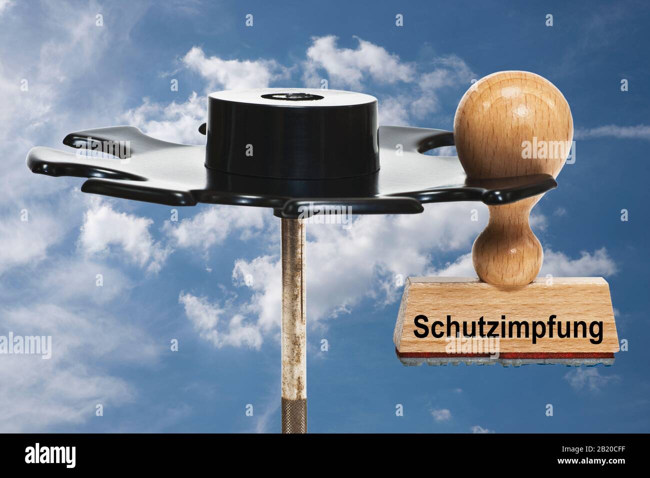 a stamp with the inscription Schutzimpfung (Protective vaccination) hangs in a stamp rack, background sky Stock Photo