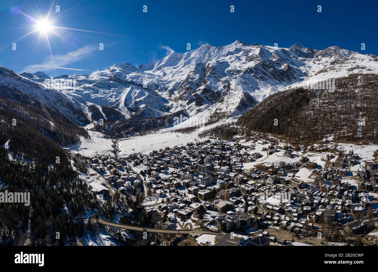 Aerial panorama of the famous Saas Fee village and ski resort by the Dom mountain, the tallest entirely in Switzerland in the alps on a sunny winter d Stock Photo