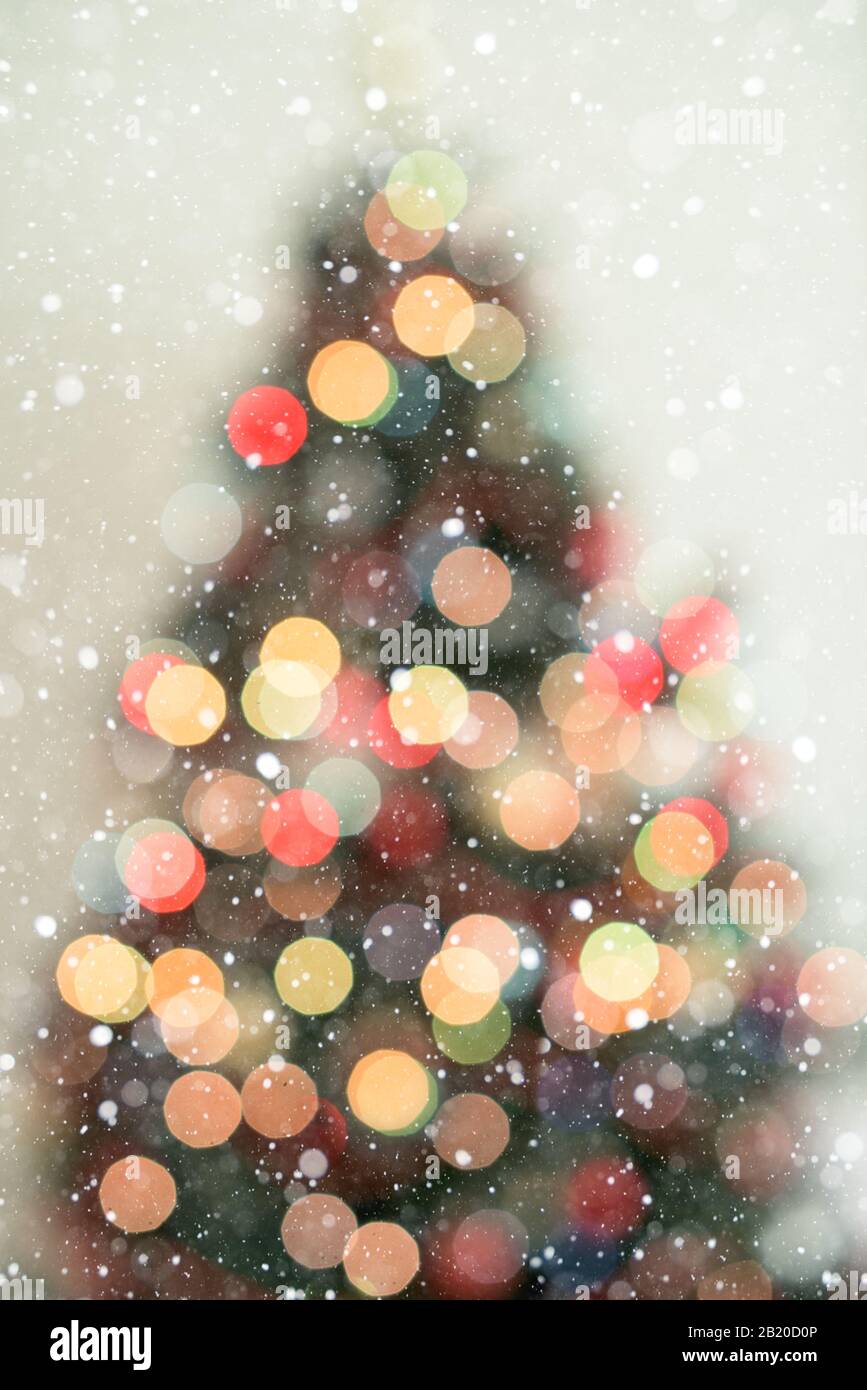 Bokeh christmas tree background with snowfall - defocused lights Stock Photo