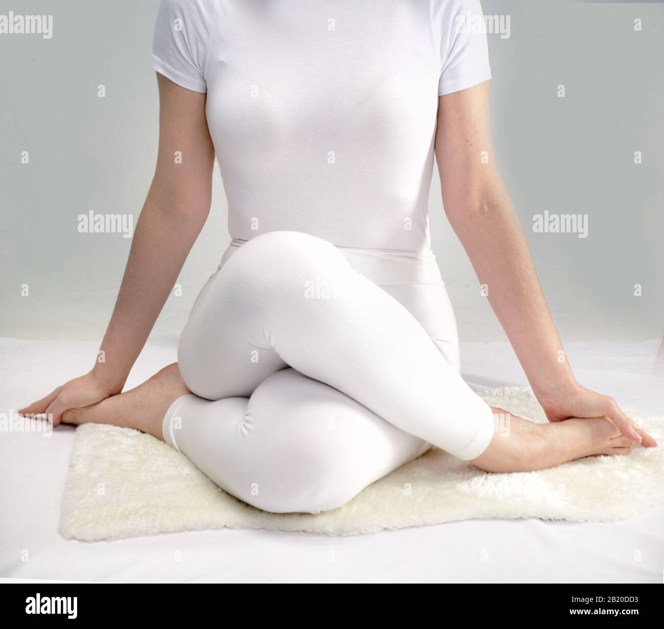 woman in white dress practicing yoga poses Stock Photo