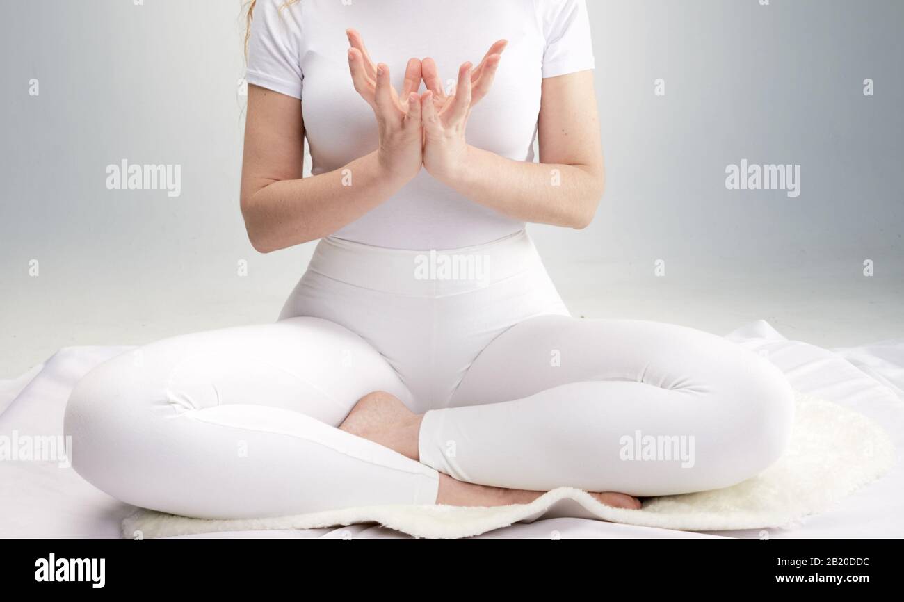woman in white dress practicing yoga poses Stock Photo