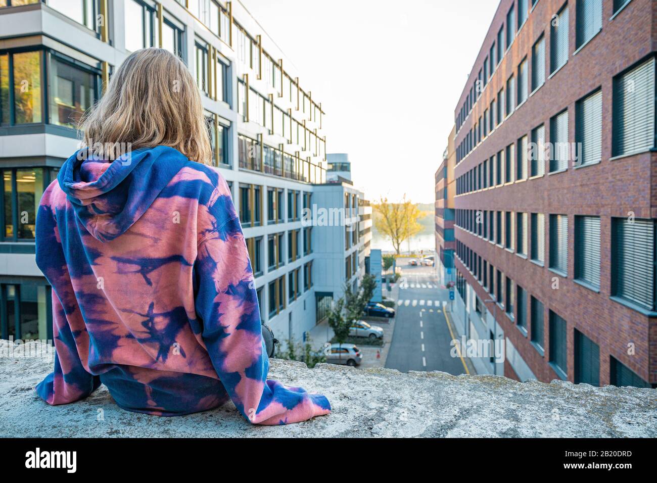 Young woman sitting wall city hi-res stock photography and images - Alamy
