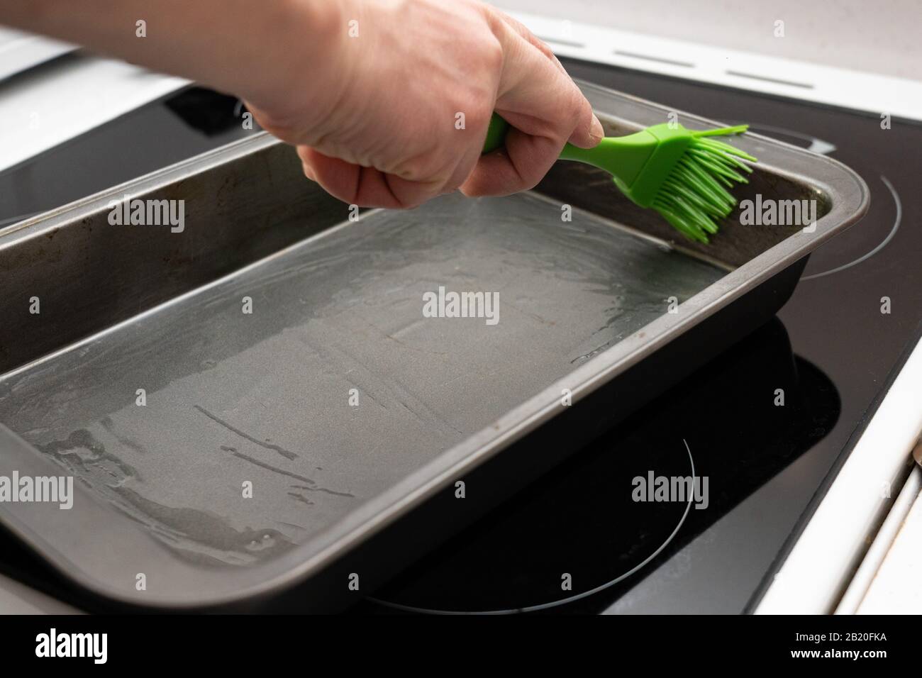 greasing baking sheet with oil. Cooking a cake tin Stock Photo