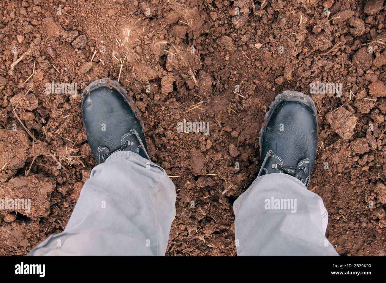 Work boot isolated on clay soil. Shoes for work. Stock Photo