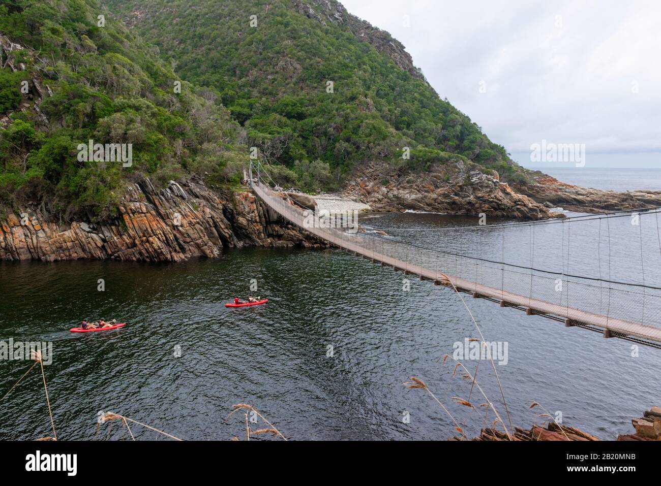 Canoeists paddle under a suspension bridge at Storms River Mouth