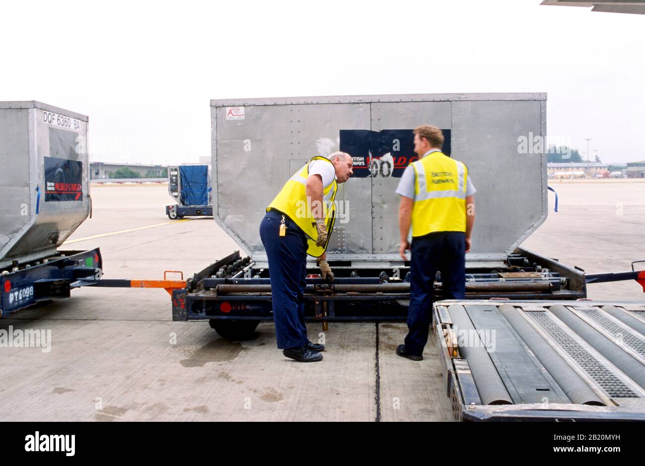 Baggage handlers (fleet service clerks) loading an airplane. Stock Photo