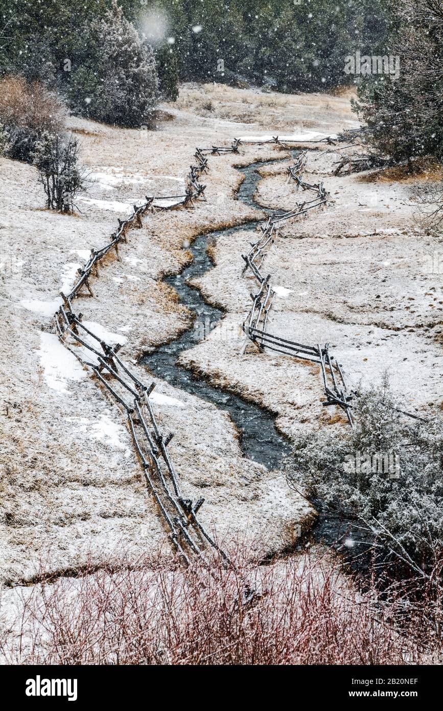 Post and rail fence and stream in fresh winter snow; near Salida; Colorado; USA Stock Photo