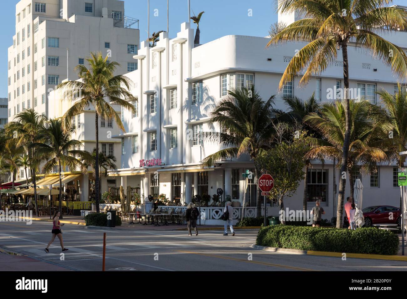 Pople walking by the Art Deco Carlyle condos on Ocean Drive in Miami