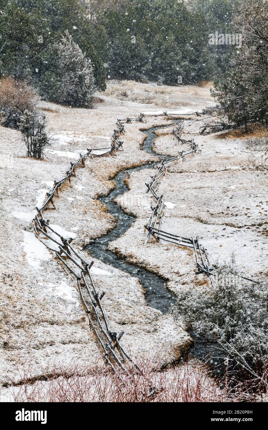 Post and rail fence and stream in fresh winter snow; near Salida; Colorado; USA Stock Photo